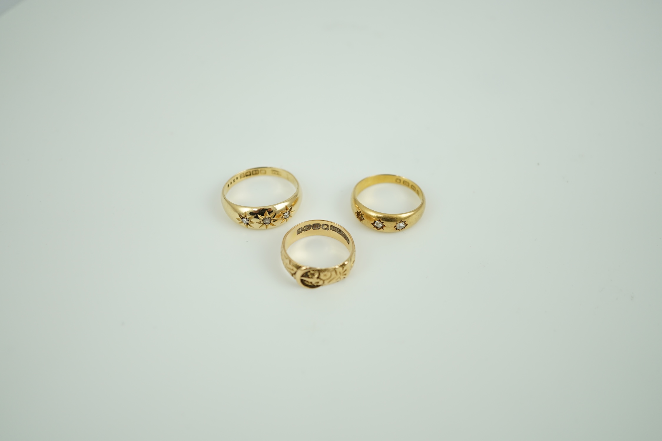 A Victorian 18ct gold buckle ring, size K/L, a Victorian 18ct gold and gypsy set three stone diamond ring (stone missing) and a later 18ct gold and gypsy set three stone diamond ring